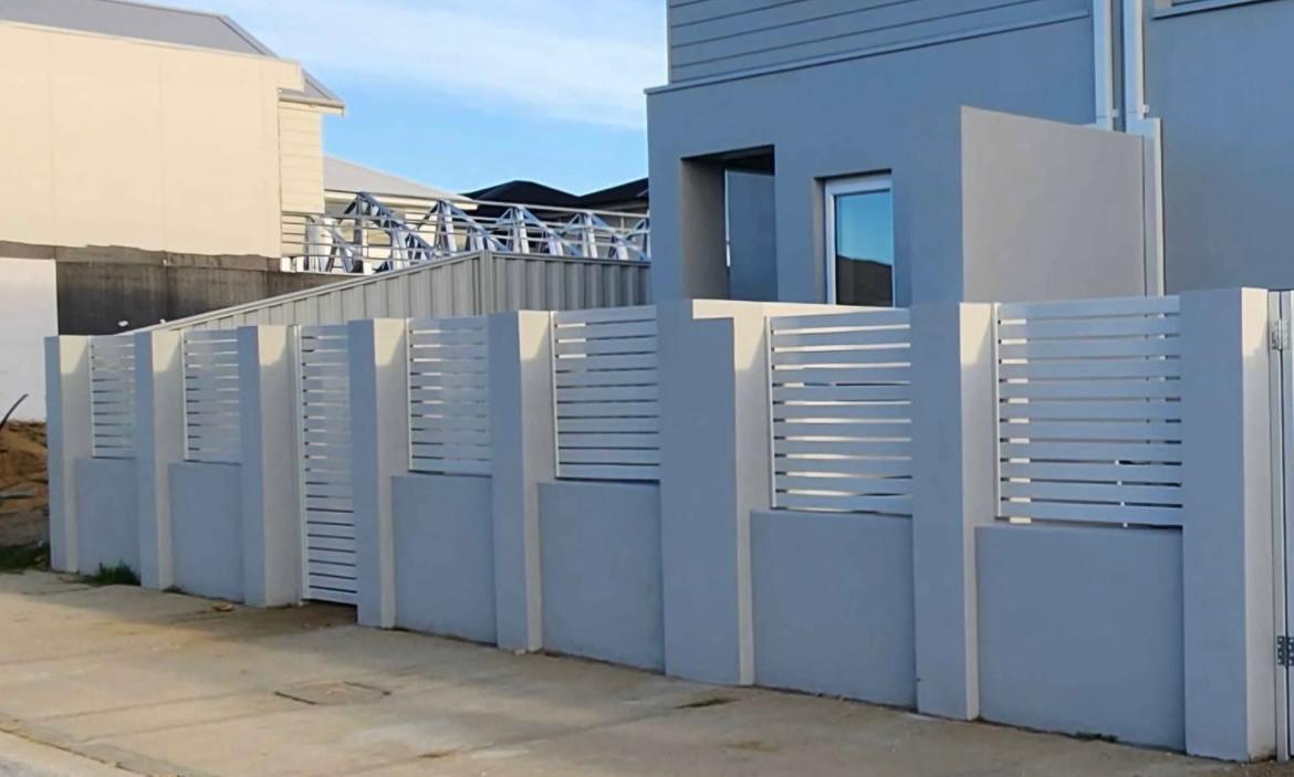 Light grey front fence with horizontal slat panels between rendered pillars on a new home
